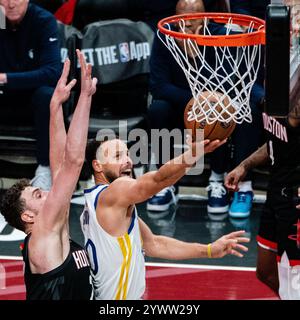 Houston, États-Unis. 11 décembre 2024. Stephen Curry (R) des Golden State Warriors dépose le ballon lors du match quart de finale de la Coupe NBA 2024-2025 entre les Golden State Warriors et les Houston Rockets à Houston, aux États-Unis, le 11 décembre 2024. Crédit : Chen Chen/Xinhua/Alamy Live News Banque D'Images