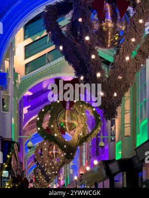 Des lumières colorées et des guirlandes ornent Burlington Arcade, créant une atmosphère festive pour les vacanciers et les visiteurs de Londres. Banque D'Images