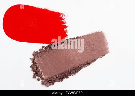 Composition de frottis de rouge à lèvres et de frottis d'ombre à paupières dans différentes nuances sur un fond clair, mettant en valeur des textures riches et des couleurs vibrantes. Banque D'Images