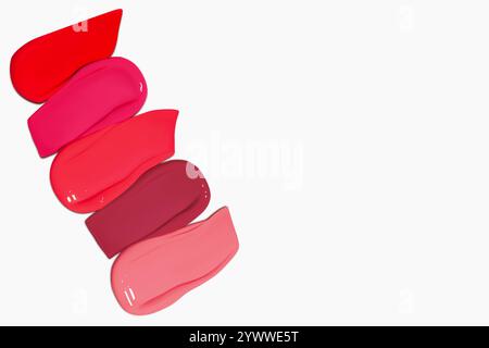 Composition de frottis de rouge à lèvres rouges dans différentes nuances, y compris rouge foncé, rouge clair, Bordeaux et rose, isolé sur un fond clair. Banque D'Images