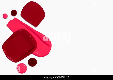 Composition de frottis et gouttes de rouge à lèvres dans différentes nuances, y compris rouge foncé, rouge clair, Bordeaux et rose, isolé sur un fond clair. Banque D'Images