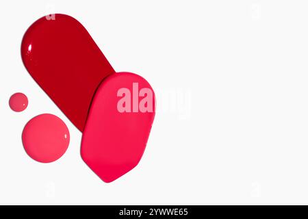Composition de frottis et gouttes de rouge à lèvres dans différentes nuances, y compris rouge foncé, rouge clair, Bordeaux et rose, isolé sur un fond clair. Banque D'Images
