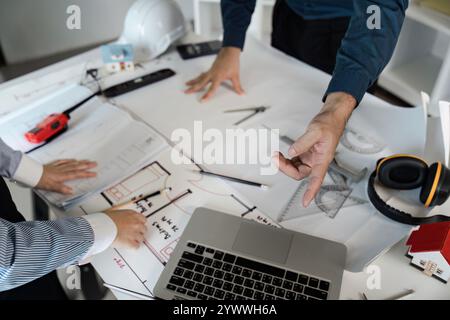 Ingénieurs et architectes collaborent sur des conceptions de plans dans un environnement de bureau moderne avec des idées innovantes Banque D'Images