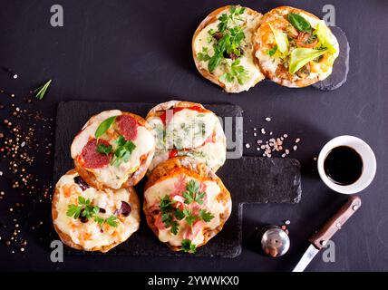 Mini pizzas - pizzeria - nappées de fromage et de tomates, de jambon italien et de piment Banque D'Images