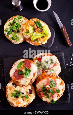 Mini pizzas - pizzeria - nappées de fromage et de tomates, de jambon italien et de piment Banque D'Images