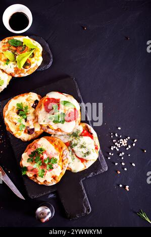 Mini pizzas - pizzeria - nappées de fromage et de tomates, de jambon italien et de piment Banque D'Images