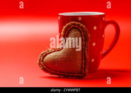 Une délicieuse combinaison d'une tasse de café vapeur et d'un cadeau en forme de cœur, idéal pour les moments de la Saint-Valentin ou les gestes romantiques Banque D'Images