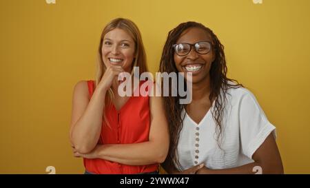 Femmes amis souriant ensemble sur fond jaune isolé heureux et détendu Banque D'Images