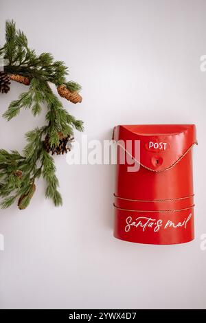 Boîte aux lettres rouge unique pour le courrier du Père Noël décorée d'une couronne festive pendant la saison de Noël et du nouvel an Banque D'Images