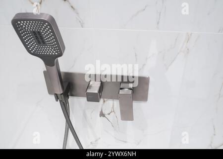 Robinet chromé de luxe et douche dans la cabine de douche avec murs en marbre blanc. Cabine de douche de luxe moderne. Banque D'Images
