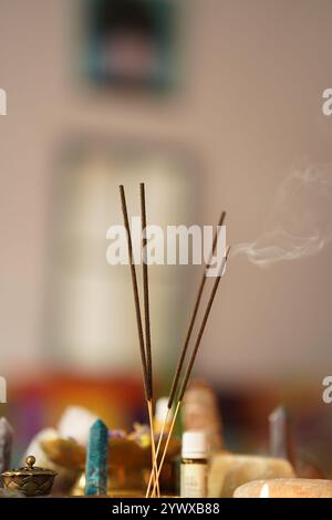 Composition avec des bâtons d'encens fumants et des pierres de spa sur fond flou Banque D'Images