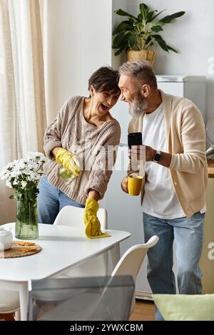 Couple mature apprécie la compagnie des autres tout en nettoyant et en partageant des moments joyeux ensemble Banque D'Images