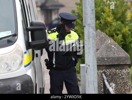 Un officier de la Garda se tient près d'une propriété sur Beechwood Drive à Drogheda, où la police effectue une fouille médico-légale en relation avec la disparition de Kyran Durnin, de Co Louth. Un homme est détenu parce qu'il est soupçonné du meurtre de l'écolier irlandais. Jeudi, des policiers ont lancé des perquisitions dans deux maisons à Drogheda dans le but de découvrir toute preuve qui pourrait révéler où se trouve Kyran ou ce qui lui est arrivé. Date de la photo : jeudi 12 décembre 2024. Banque D'Images