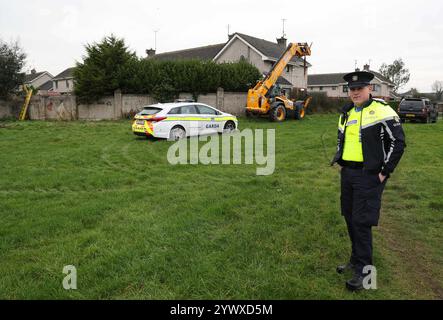 Un officier de la Garda se tient près d'une propriété sur Beechwood Drive à Drogheda, où la police effectue une fouille médico-légale en relation avec la disparition de Kyran Durnin, de Co Louth. Un homme est détenu parce qu'il est soupçonné du meurtre de l'écolier irlandais. Jeudi, des policiers ont lancé des perquisitions dans deux maisons à Drogheda dans le but de découvrir toute preuve qui pourrait révéler où se trouve Kyran ou ce qui lui est arrivé. Date de la photo : jeudi 12 décembre 2024. Banque D'Images