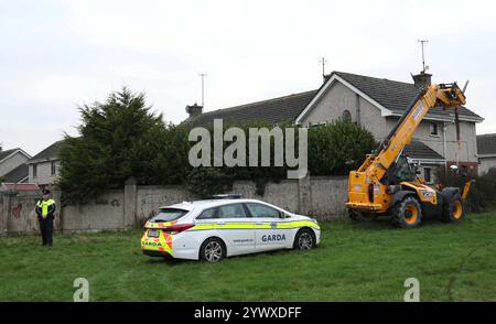 Un officier de la Garda se tient près d'une propriété sur Beechwood Drive à Drogheda, où la police effectue une fouille médico-légale en relation avec la disparition de Kyran Durnin, de Co Louth. Un homme est détenu parce qu'il est soupçonné du meurtre de l'écolier irlandais. Jeudi, des policiers ont lancé des perquisitions dans deux maisons à Drogheda dans le but de découvrir toute preuve qui pourrait révéler où se trouve Kyran ou ce qui lui est arrivé. Date de la photo : jeudi 12 décembre 2024. Banque D'Images