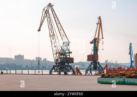 Vladivostok, Russie - 21 octobre 2012 : grues industrielles au port avec la ville skyline en arrière-plan. Banque D'Images