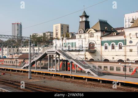 Vladivostok, Russie - 21 octobre 2012 : vue sur la gare historique avec un pont piétonnier et des trains. Banque D'Images