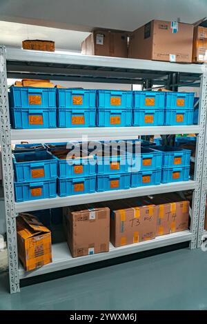 Étagères de rangement organisées dotées de bacs et de boîtes bleus pour une efficacité et une commande accrues Banque D'Images