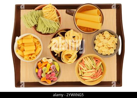 Variétés de pâtes multicolores. Types de pâtes non cuites dans des bols sur un plateau. Isolé sur fond blanc. Stocker différents types de pâtes à la maison Banque D'Images