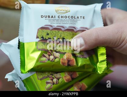 Hambourg, Allemagne. 10 décembre 2024. Un employé dans un kiosque tient plusieurs barres de chocolat Dubaï dans sa main. Crédit : Marcus Brandt/dpa/Alamy Live News Banque D'Images