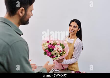 Fleuriste s'engage avec un homme pour aider à choisir l'arrangement floral parfait dans sa boutique. Banque D'Images