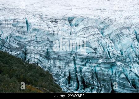 Vue imprenable sur l'immense glacier Fox en Nouvelle-Zélande, avec des crevasses de glace gelées, des bandes de moraine et d'arbres de la forêt tropicale, photographie de paysage Banque D'Images