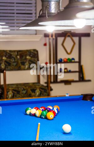 Boules de billard sur une table bleue. L'image montre un ensemble de boules de billard brillantes méticuleusement disposées dans un rack triangulaire sur un feutre bleu immaculé. Banque D'Images