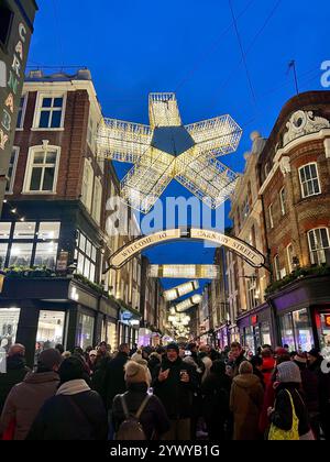Centre de Londres, Soho, Carnaby Street Holiday lumières au crépuscule avec les touristes et les acheteurs dans les rues. Heure bleue. Banque D'Images