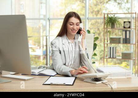 Banquier parlant au téléphone à table dans le bureau Banque D'Images