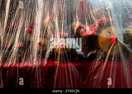 12 décembre 2024, Barcelone, Espagne : une feuille de plastique recouvre un étal vendant le traditionnel Tio de Nadal catalan (journal de Noël) pour le protéger de la pluie au marché de Noël Santa Llucia de Barcelone. Crédit : Jordi Boixareu/Alamy Life News Banque D'Images