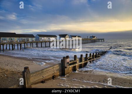 Southwold, Suffolk, Angleterre, Royaume-Uni - Southwold jetée au lever du soleil avec des vagues se brisant sur le bord de mer autour de la jetée et groyne Banque D'Images