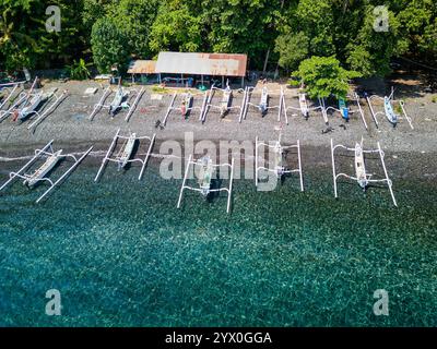 Jukung Outrigger bateaux sur une plage rocheuse et volcanique à Bali Banque D'Images