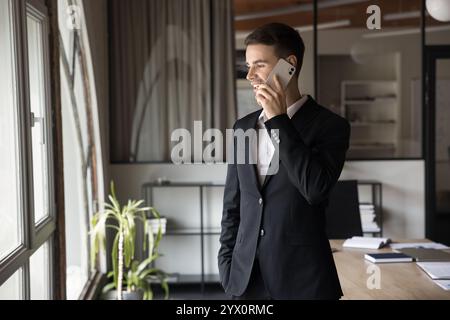 Homme d'affaires habillé en costume formel engagé dans la discussion au téléphone Banque D'Images