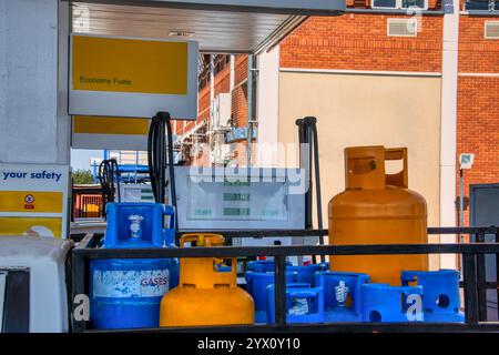 Bouteilles de gaz liquéfié, bouteille de gaz liquéfié, à une station-service pour le remplissage , à côté de la pompe à essence Banque D'Images