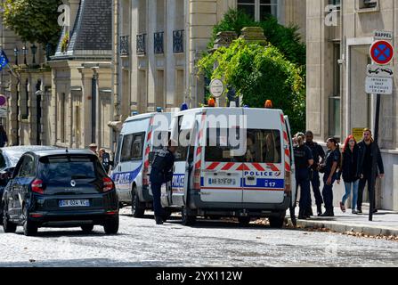Des hommes et des femmes de la police française se sont rassemblés autour de deux véhicules dans la rue à Paris, en France Banque D'Images
