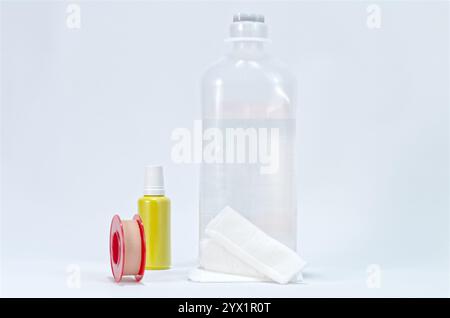 Fournitures médicales, y compris bouteille d'eau goutte à goutte, goutte à goutte antiseptique, ruban adhésif et bandage sur fond blanc Banque D'Images