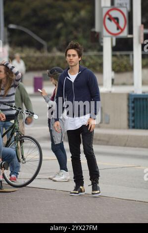 Jared Leto, décontracté dans un sweat à capuche, filme des scènes dans les rues de Santa Monica, s'engageant avec l'équipage et faisant du vélo. Banque D'Images