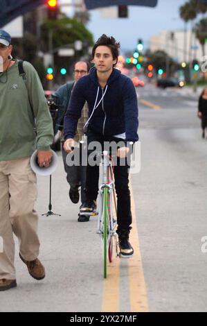 Jared Leto, décontracté dans un sweat à capuche, filme des scènes dans les rues de Santa Monica, s'engageant avec l'équipage et faisant du vélo. Banque D'Images