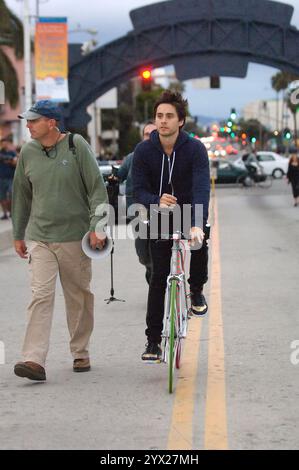 Jared Leto, décontracté dans un sweat à capuche, filme des scènes dans les rues de Santa Monica, s'engageant avec l'équipage et faisant du vélo. Banque D'Images