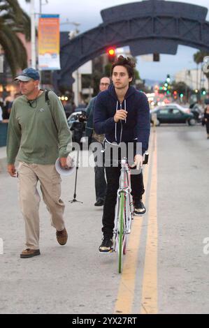 Jared Leto, décontracté dans un sweat à capuche, filme des scènes dans les rues de Santa Monica, s'engageant avec l'équipage et faisant du vélo. Banque D'Images