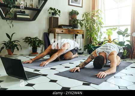 Hommes, détente et yoga de méditation à la maison de fitness holistique, guérison spirituelle et pleine conscience. Actif, les gens et l'ordinateur portable pour pilates exercice de Banque D'Images