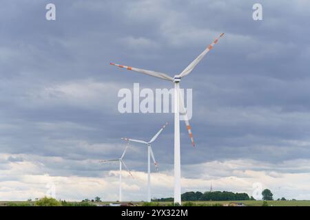 Une vue des éoliennes produisant de l'électricité à partir de sources d'énergie renouvelables sur fond de prairies et de nuages. Banque D'Images