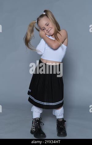 Jeune mannequin s position ludique dans des vêtements tendance, parfait pour le marketing de vêtements pour enfants. Met l'accent sur l'enfance animée Banque D'Images