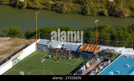 Reynosa. 11 décembre 2024. Une photo de drone aérien prise le 11 décembre 2024 montre des gens jouant au football dans un abri dans la ville frontalière de Reynosa, Tamaulipas, au Mexique. Reynosa, une ville frontalière de Tamaulipas, se trouve de l'autre côté du Rio Grande de McAllen, Texas des États-Unis. En raison de sa situation géographique, Reynosa sert de porte d'entrée majeure pour les migrants d'Amérique centrale et d'autres régions qui tentent d'entrer aux États-Unis. Les refuges de cette région fournissent un logement temporaire aux migrants en attente de demandes d'asile, de permis de transit ou de retour dans leur foyer. Crédit : Li Muzi/Xinhua/Alamy Live News Banque D'Images