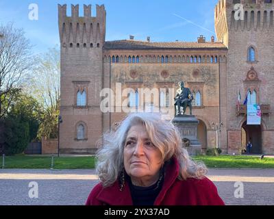 Busseto, Parme, Italie - 23 novembre 2024 Une femme se tient sur la piazza giuseppe verdi à busseto, italie, avec la statue du compositeur giuseppe verdi et p Banque D'Images