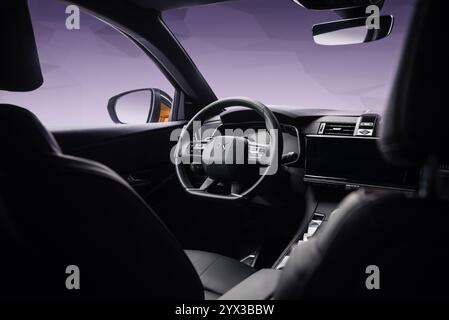 Intérieur de DS7 Crossback. Vue grand angle depuis le siège passager arrière : console centrale, tableau de bord et volant du vus multisegment français. Banque D'Images