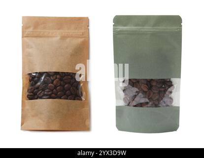 Sachets en papier avec des grains de café isolés sur blanc. Emballage pour produit Banque D'Images