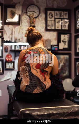 Tatouage traditionnel de dragon japonais en cours sur le dos d'une femme Banque D'Images