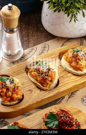 bruschetta avec tartare de saumon sur une planche de service Banque D'Images
