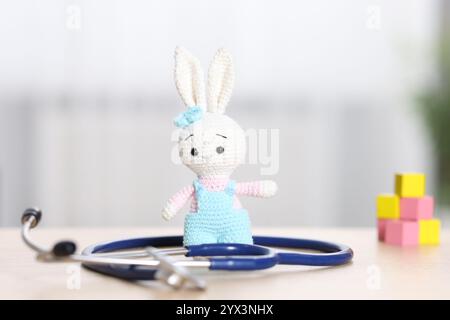 Concept pédiatrique. Lapin jouet avec stéthoscope sur table à l'intérieur Banque D'Images